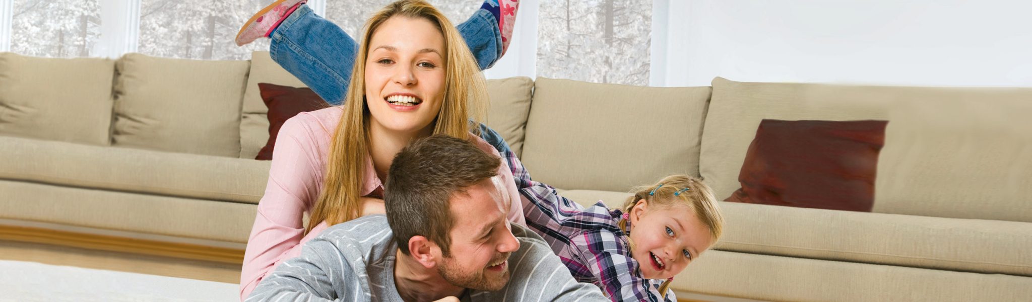 Happy family of four sitting on sofa in living room